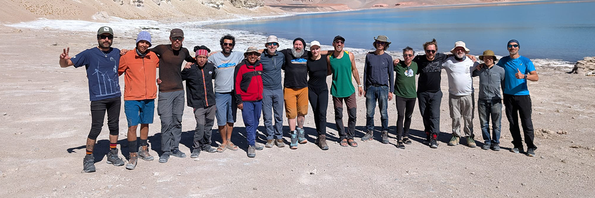 A group of mountaineers celebrating happily at a camp or on a summit.