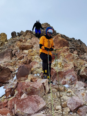 Detail of a mountaineer wearing a helmet and an ultralight harness