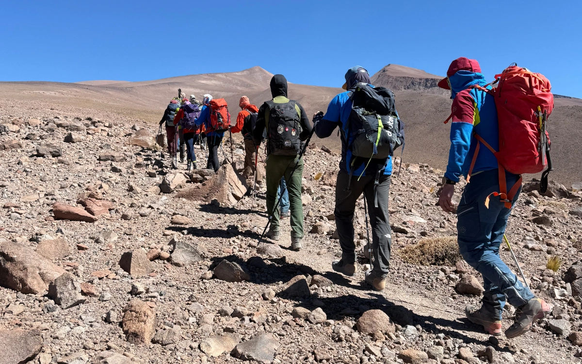 Mountaineers hiking up Mulas Muertas peak for altitude acclimatization on Ojos del Salado expedition.