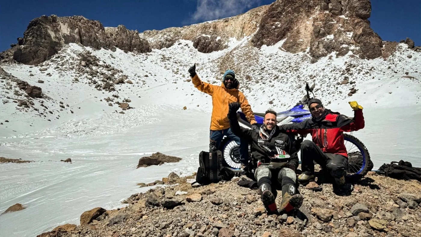 Pol Tarrés and his team celebrating with the motorcycle on the mountain